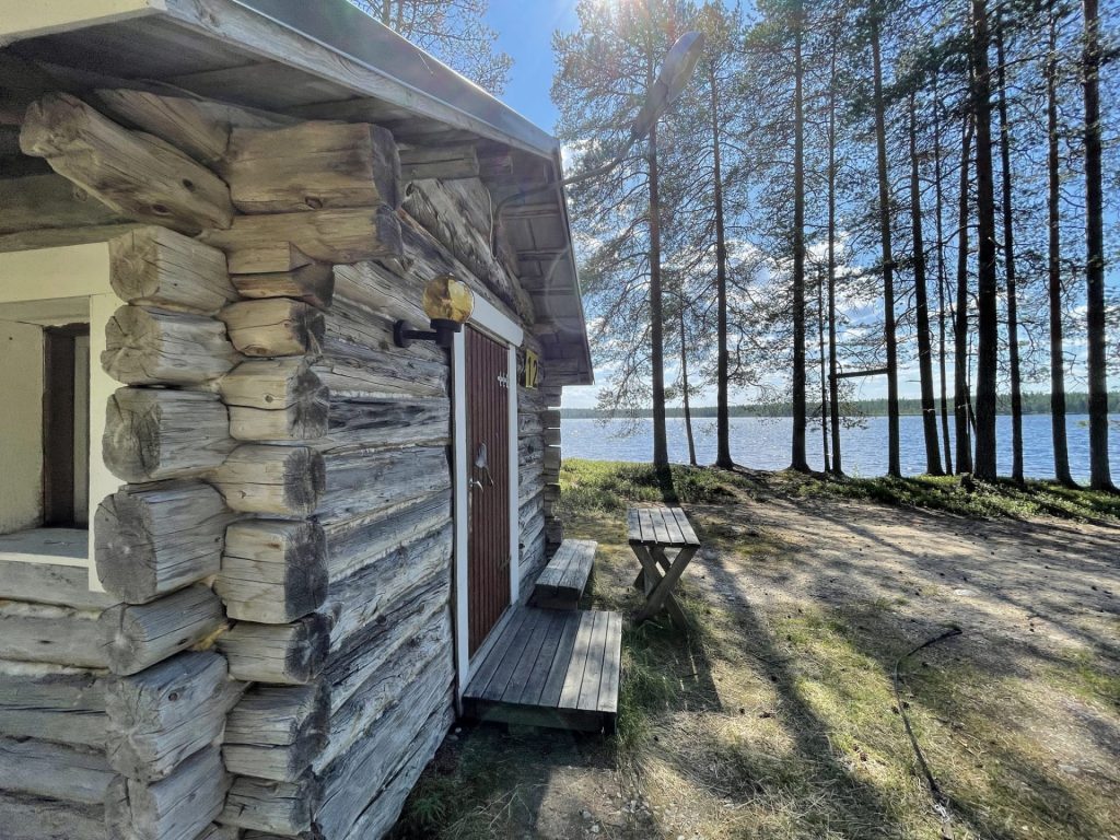Tunnelmallinen hirsimökki järven rannalla